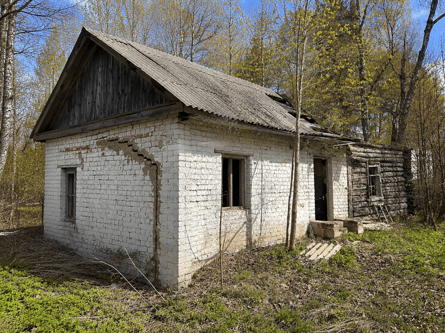 Здание проходной среди деревьев